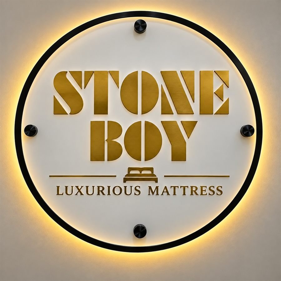 Raised gold mirror acrylic lettering reading Stone Boy Luxurious Mattress on a backlit circular board